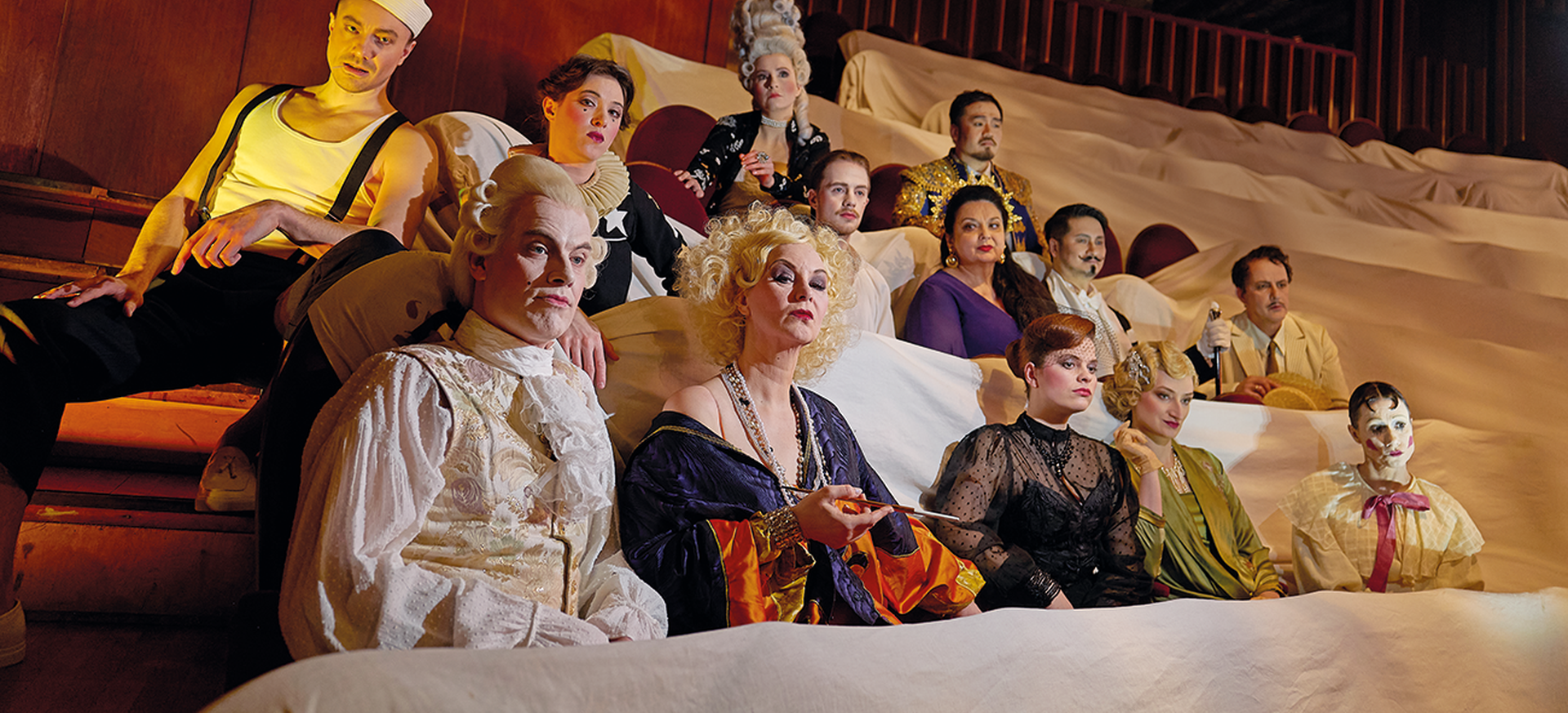 Das Ensemble der Oper Halle sitzt im zweiten Rang der Oper. Die Sitze sind mit weißen Tüchern bedeckt.